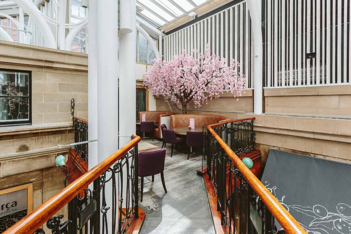 Elegant restaurant with cherry blossom tree, perfect for meetings and social events. - Banner