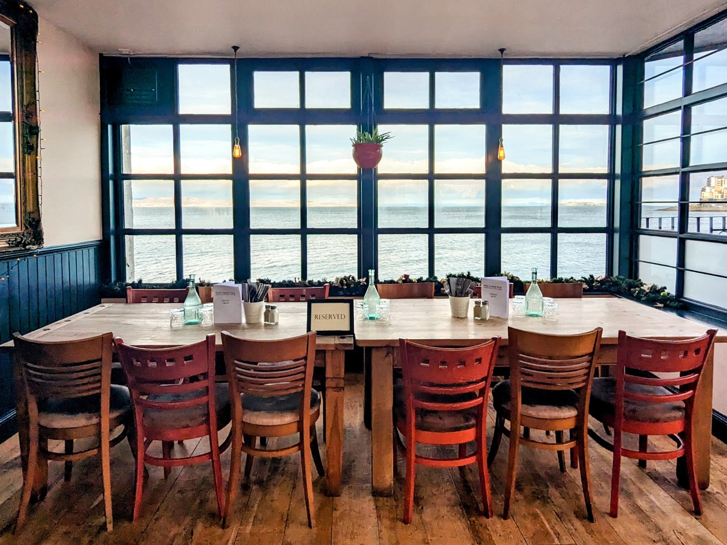 Intimate meeting space with long table and water view, perfect for corporate retreats. - Banner