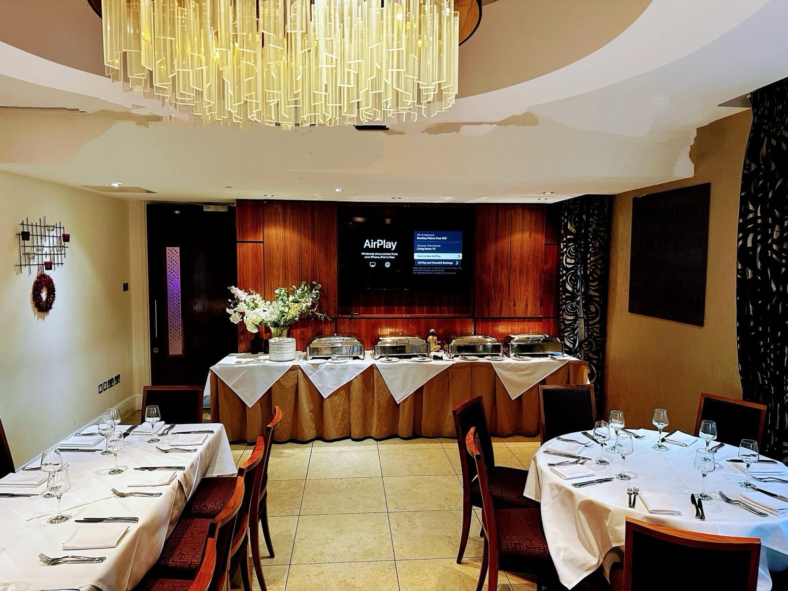 Elegant Bombay Palace event space with round tables, ideal for networking and dining. - Banner