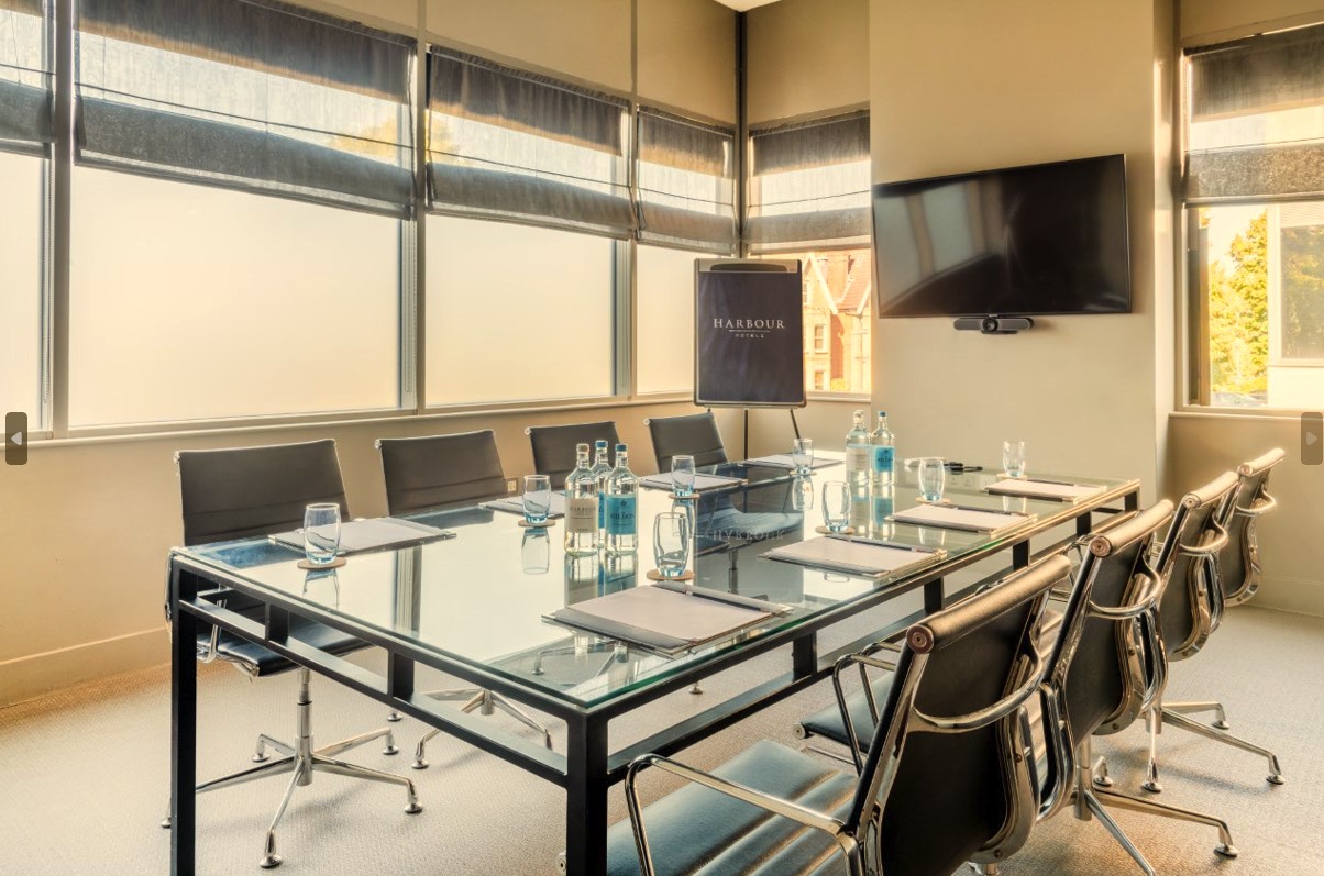 Modern conference room with glass table at Guildford Harbour Hotel for meetings and presentations. - Banner