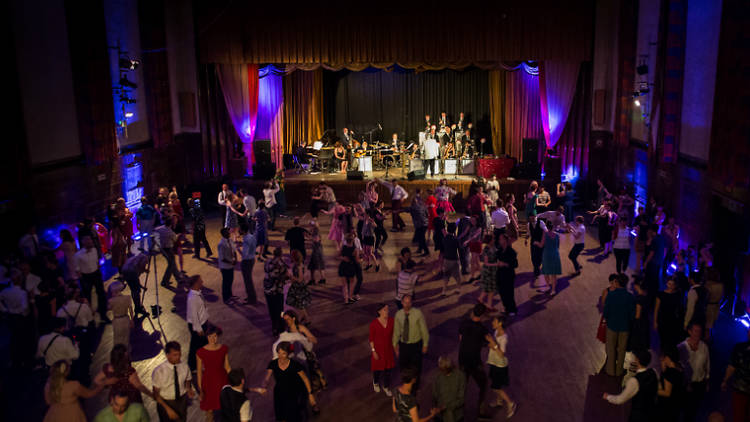 Vibrant House Café event space in Hornsey Town Hall with joyful dancing attendees.