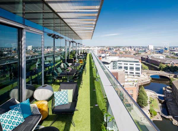 Rooftop venue with greenery and city views, perfect for networking events and gatherings. - Banner