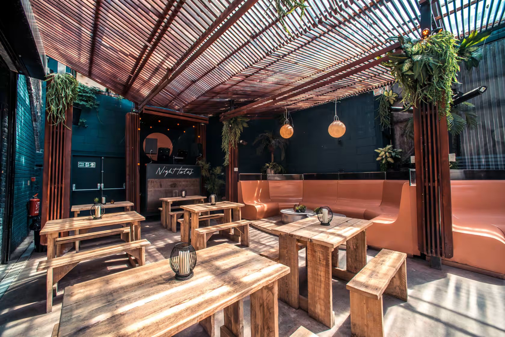 Stylish outdoor venue with wooden tables, perfect for casual events and networking.
