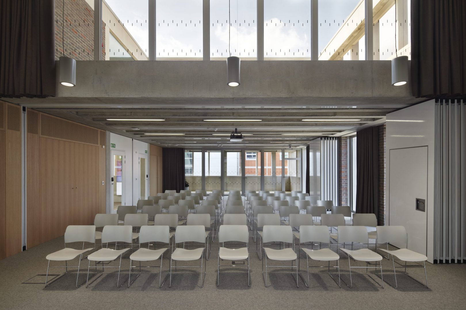 Modern meeting room with white chairs, ideal for presentations and workshops. - Banner