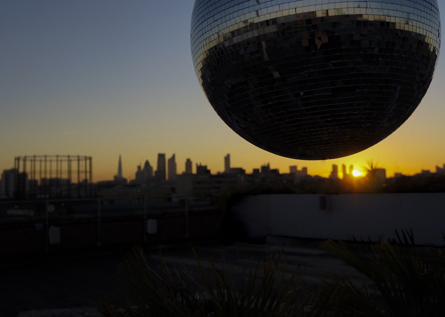 Stunning sunset at Netil360 Rooftop Bar with disco ball, ideal for events and celebrations. - Banner
