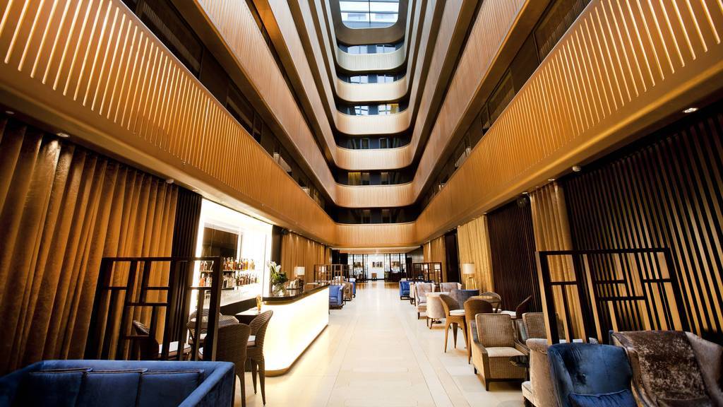 Modern hotel lobby with sleek bar, ideal for upscale events and networking. - Banner