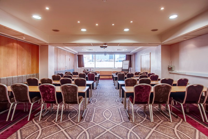 Meeting room in Leonardo Royal Hotel Birmingham with projector, ideal for corporate events.