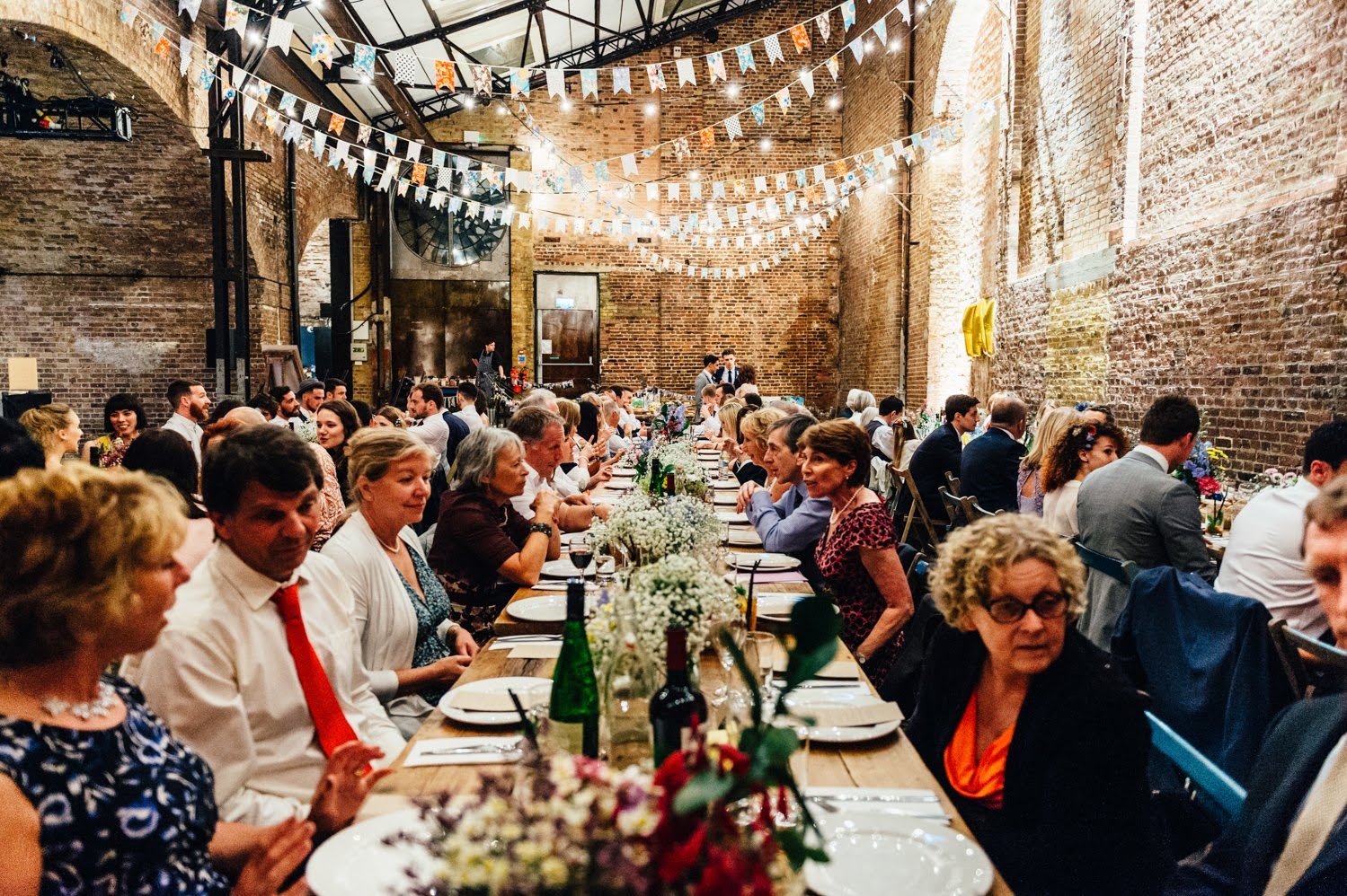 Long dining table with floral centerpieces in Village Underground for weddings and gatherings.
