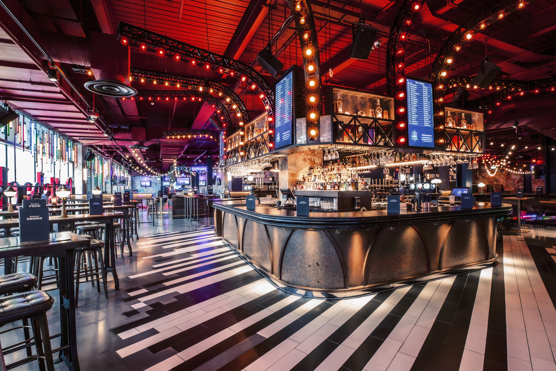 Vibrant Christmas event space with modern bar at Puttshack White City, ideal for gatherings.