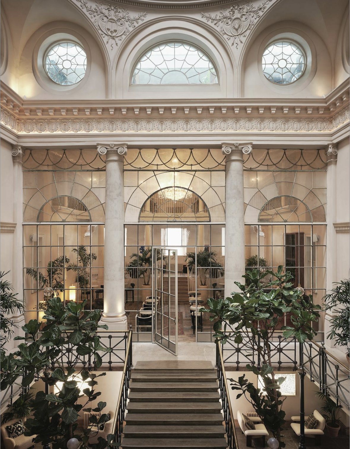 Elegant event space with tall columns and greenery for corporate functions or gatherings.
