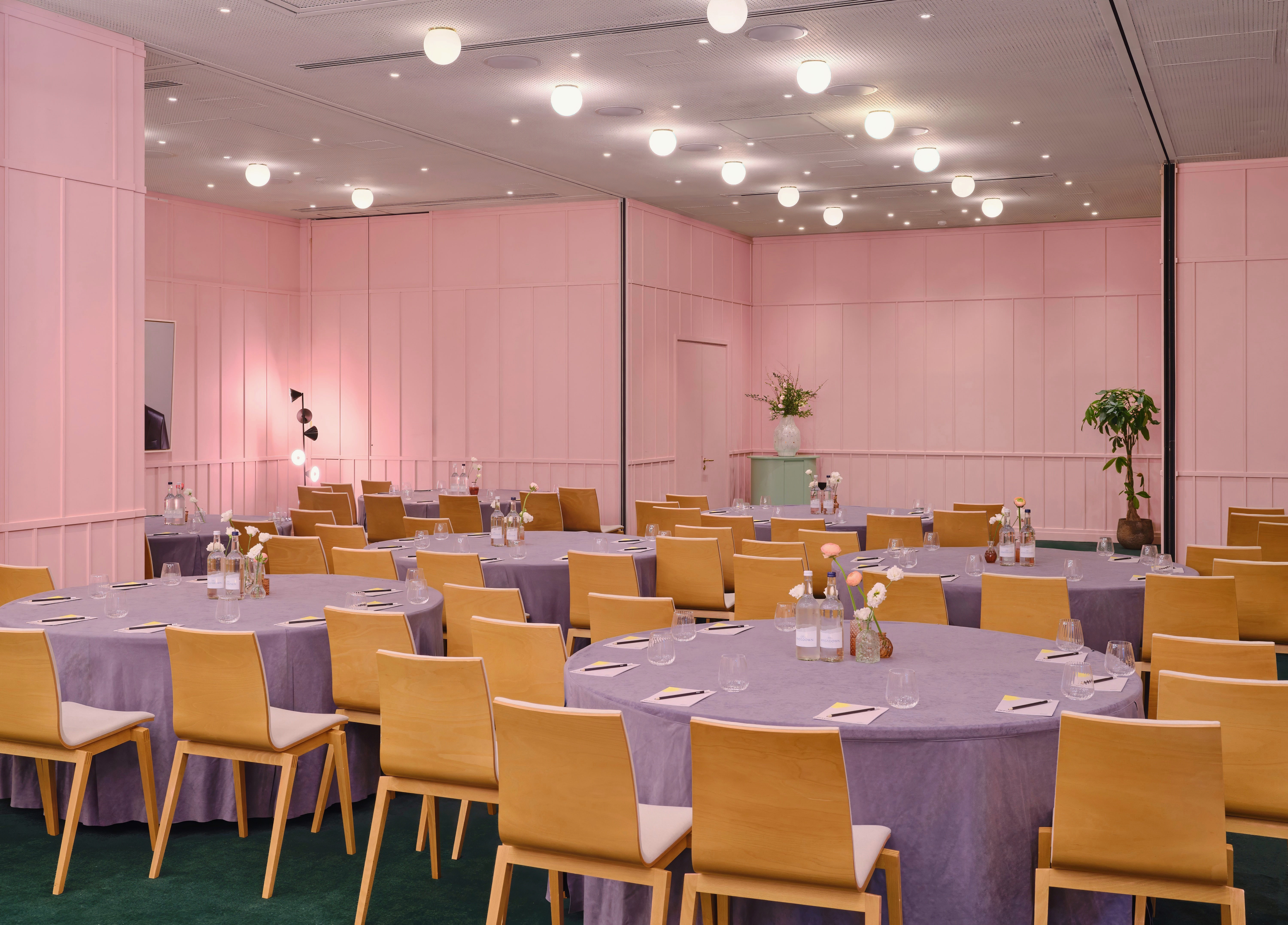 Elegant event space with round tables in art'otel London Battersea Power Station.