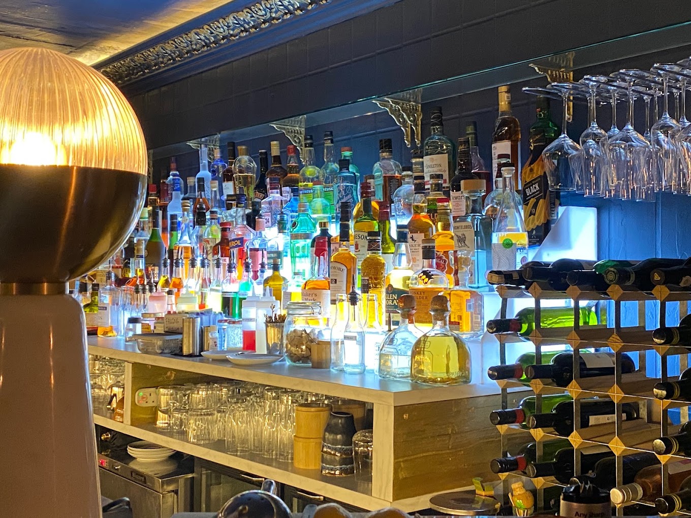 Vibrant bar setup with colorful liquor bottles for networking events at The Rabbit's Hole. - Banner