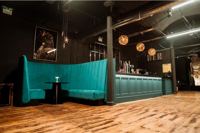 Stylish Main Room in The Den with teal seating, perfect for networking events.