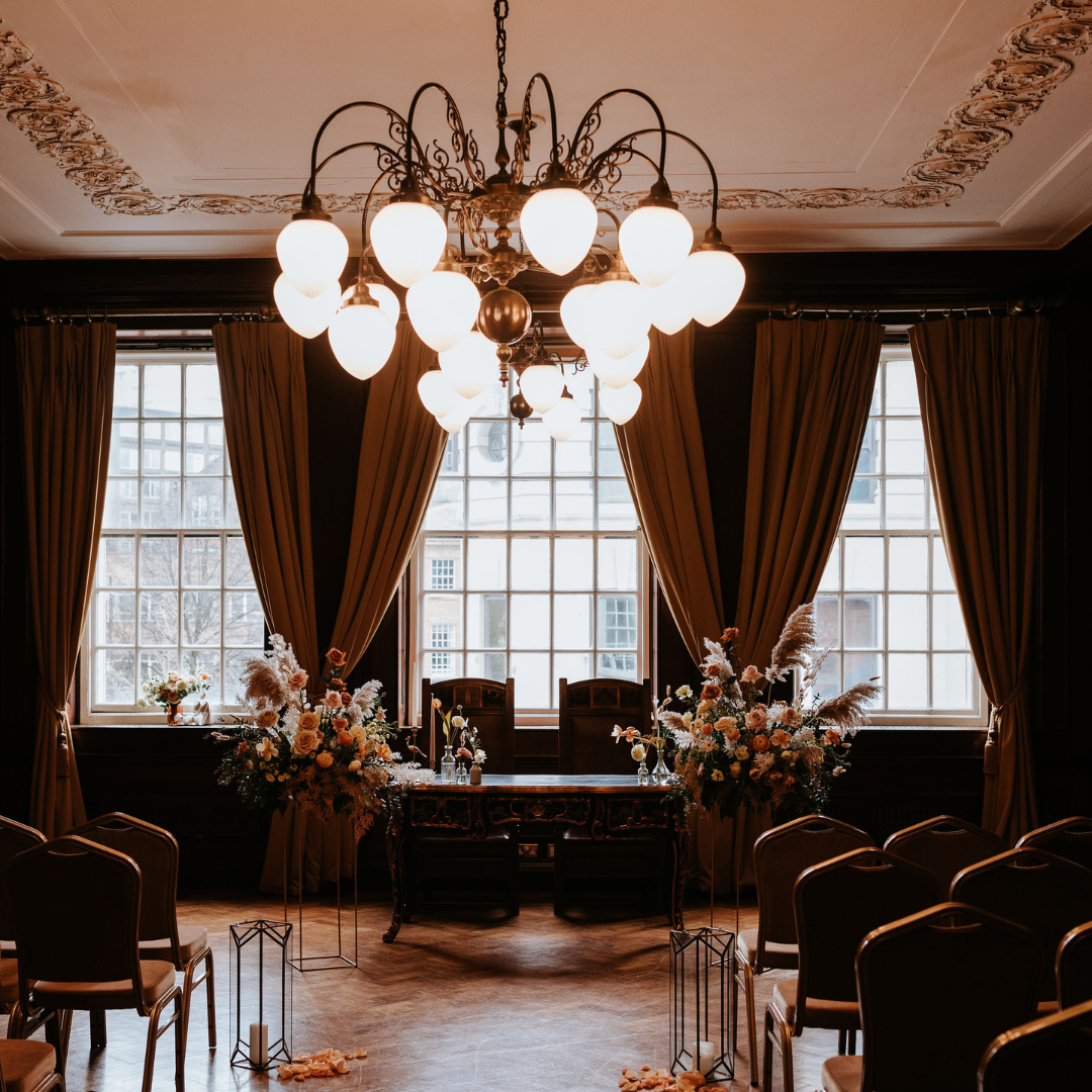 Elegant meeting space in Manchester Hall with floral centerpieces and chandelier.