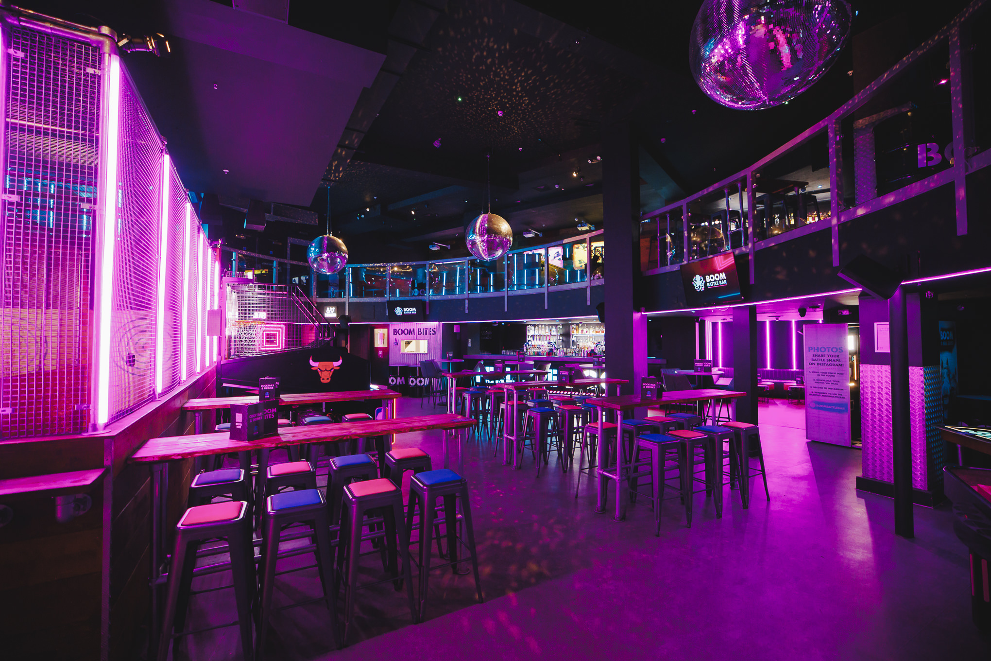 Vibrant event space with purple lighting for parties and networking in Boom Battle Bar Manchester. - Banner