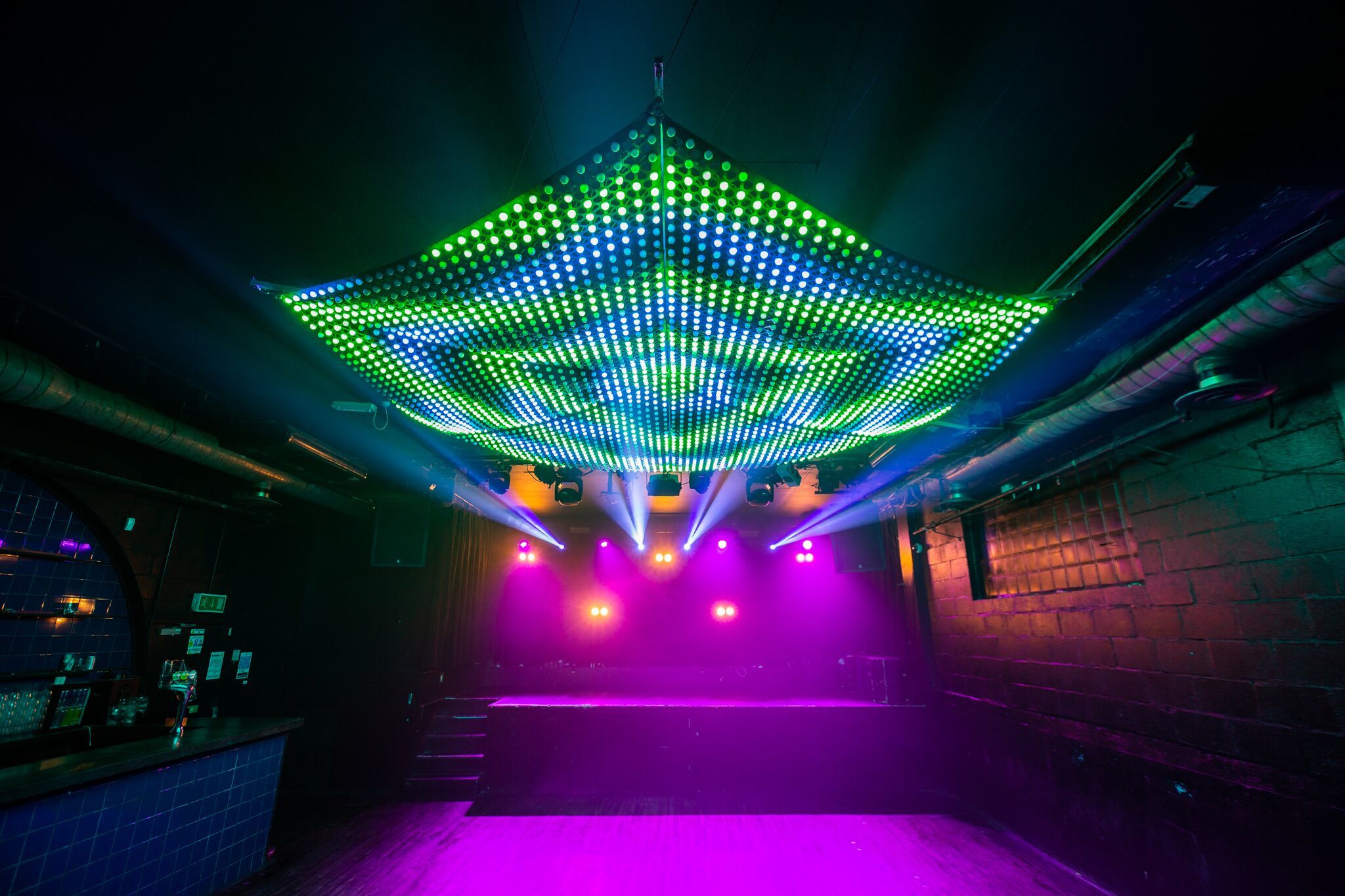 Vibrant Multiroom Event Space with LED lights, perfect for live performances and dance events.