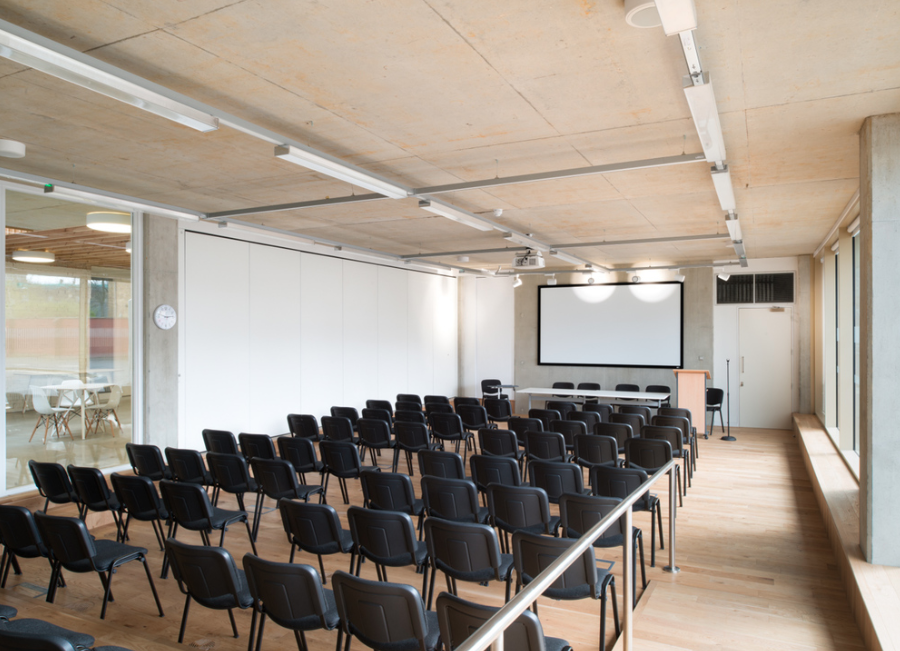 Modern conference room with ample seating for presentations and workshops. - Banner