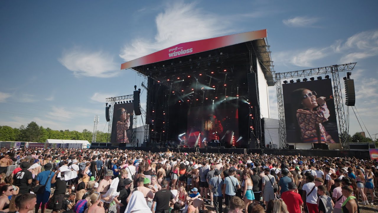 Vibrant outdoor concert at The NEC Birmingham with large crowd and impressive stage. - Banner