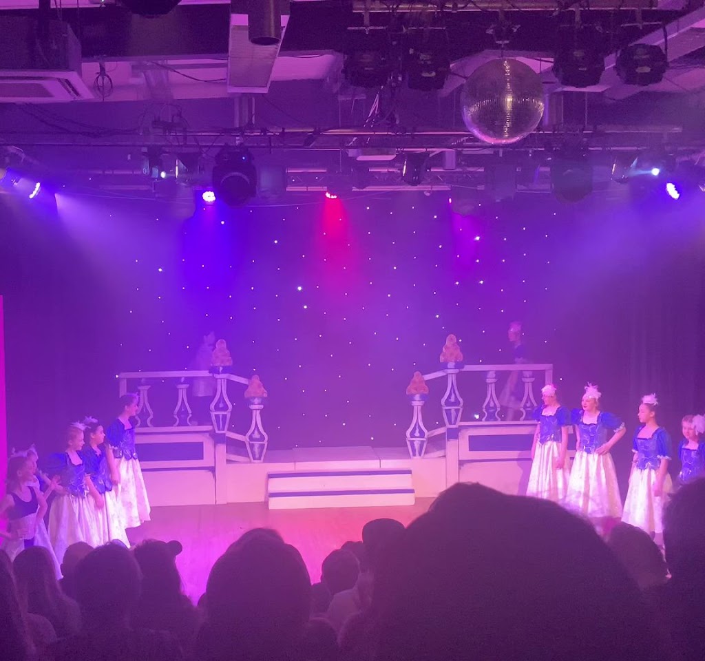 Vibrant stage with young dancers at Dovehouse Theatre for a recital or theatrical performance. - Banner