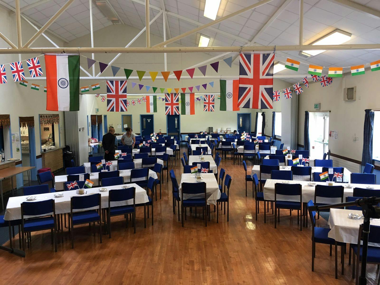 Committee Room at Layca Community Centre, vibrant multicultural event space with colorful flags. - Banner
