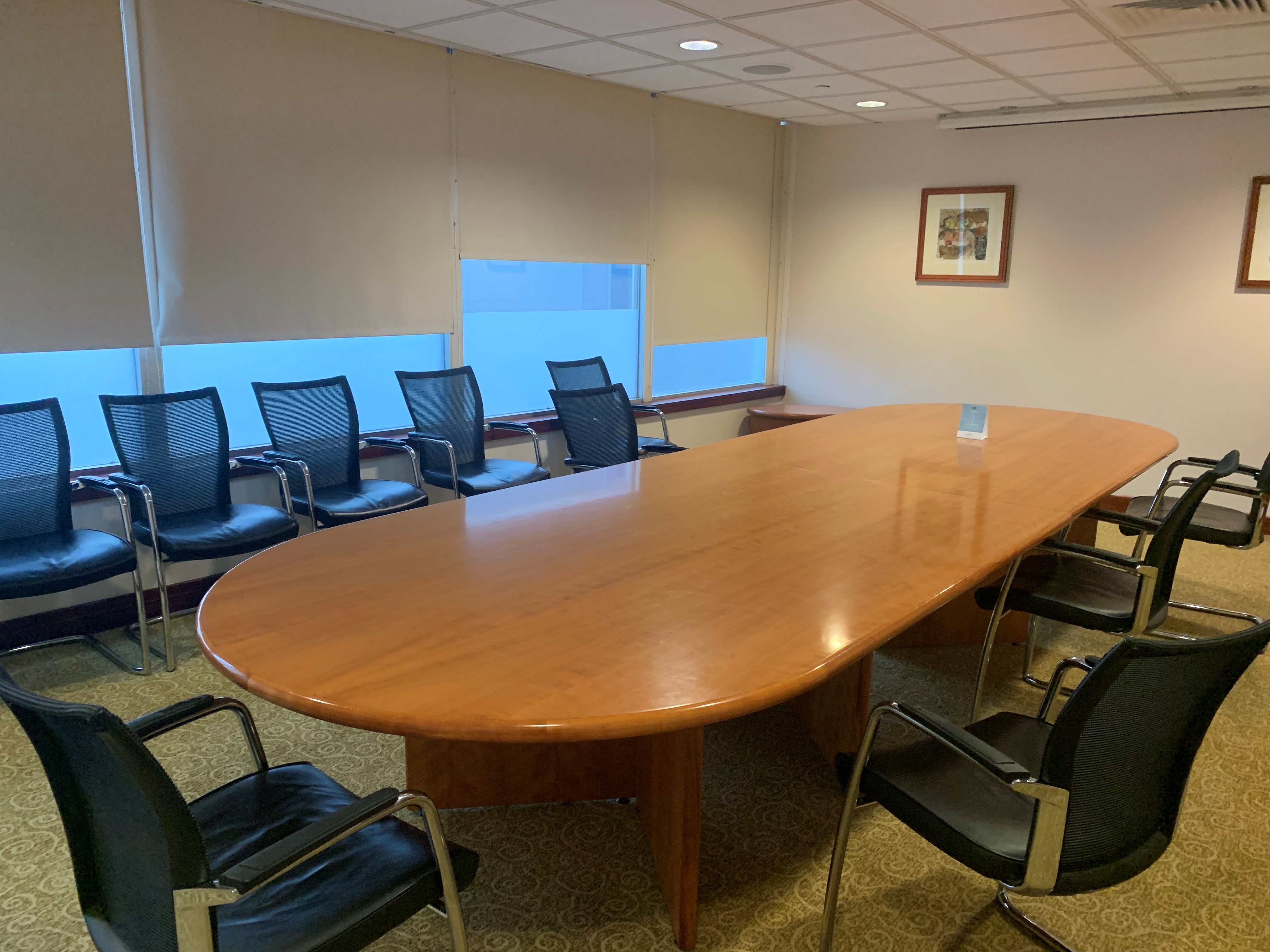 Portmeiron Suite conference room with wooden table, ideal for meetings and presentations.