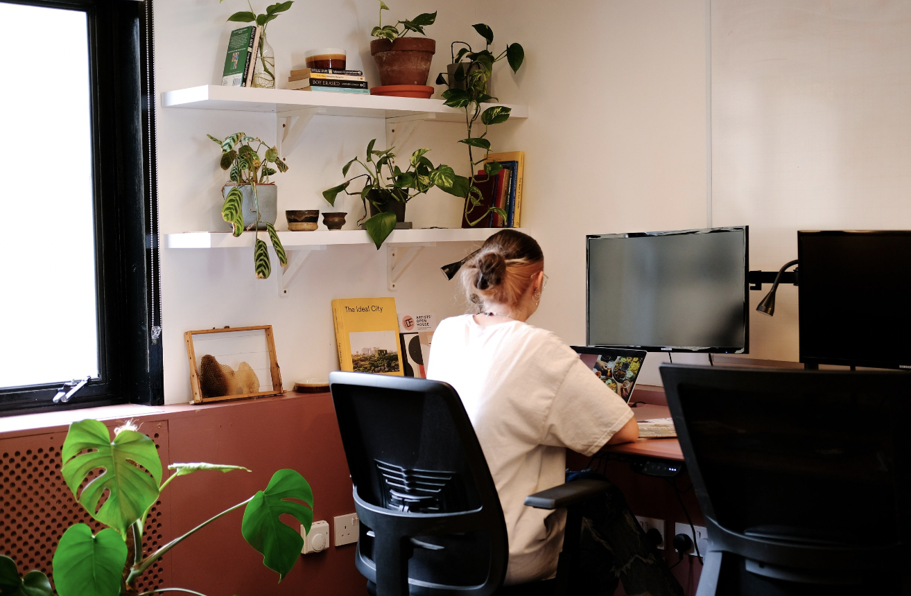 Modern coworking private office with dual monitors and natural light for productivity.