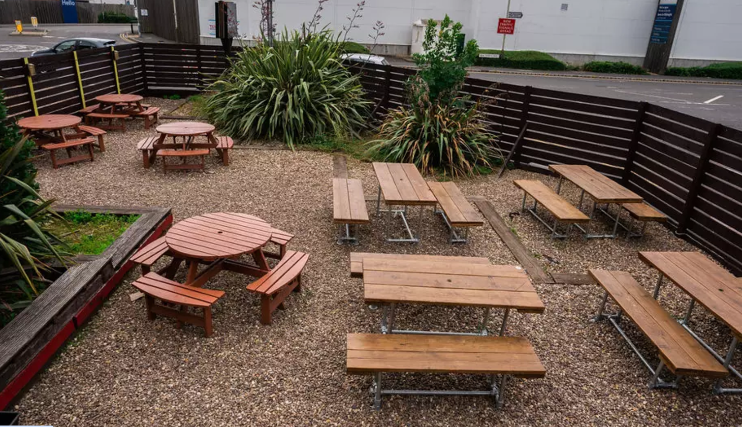 Outdoor event space at 2Funky Lounge with picnic tables for casual gatherings. - Banner