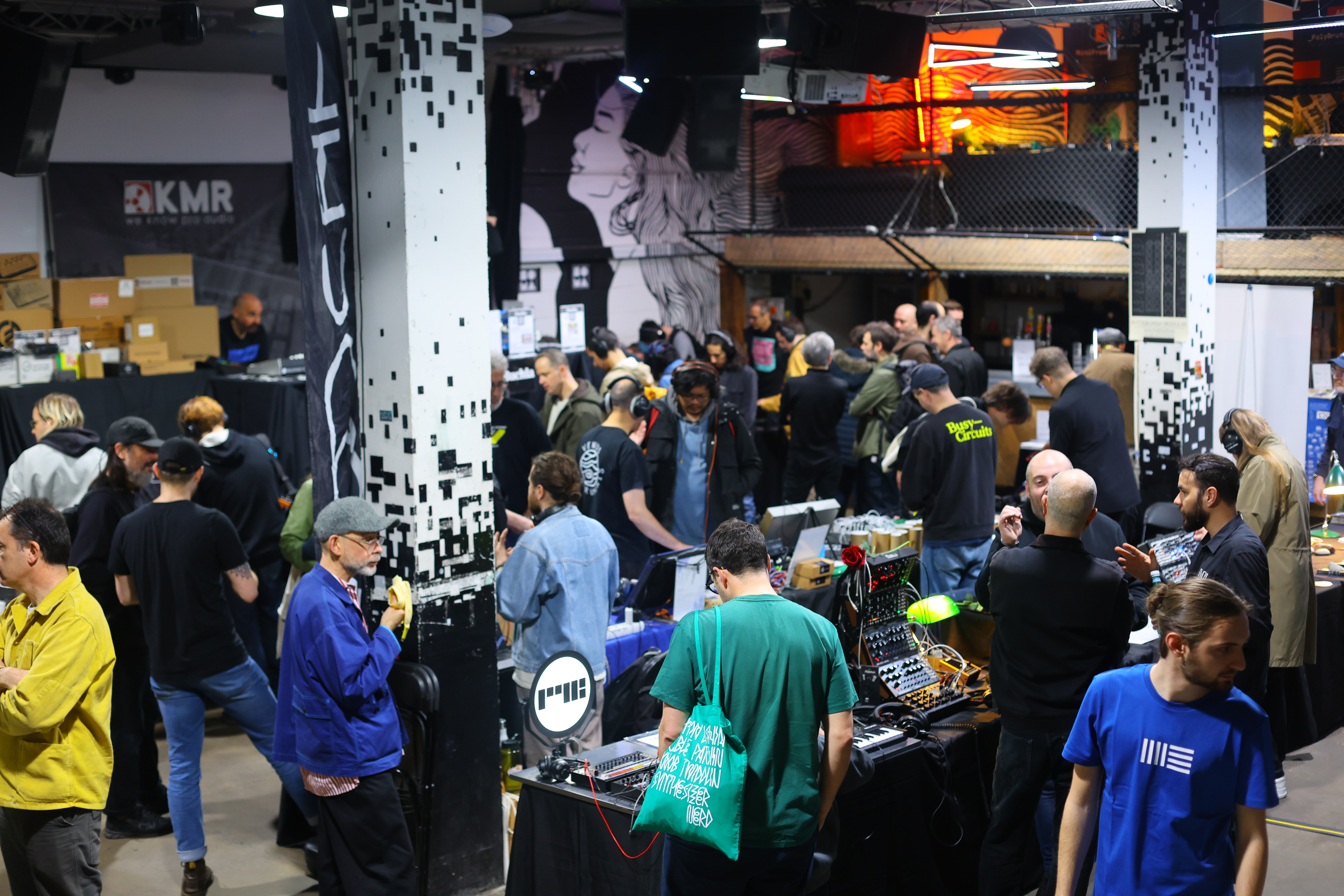 Vibrant networking event space at 90 Hackney Wick with diverse crowd and displays.