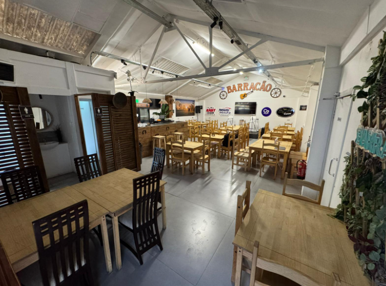 Versatile event space with wooden furniture, perfect for social gatherings and meetings. - Banner