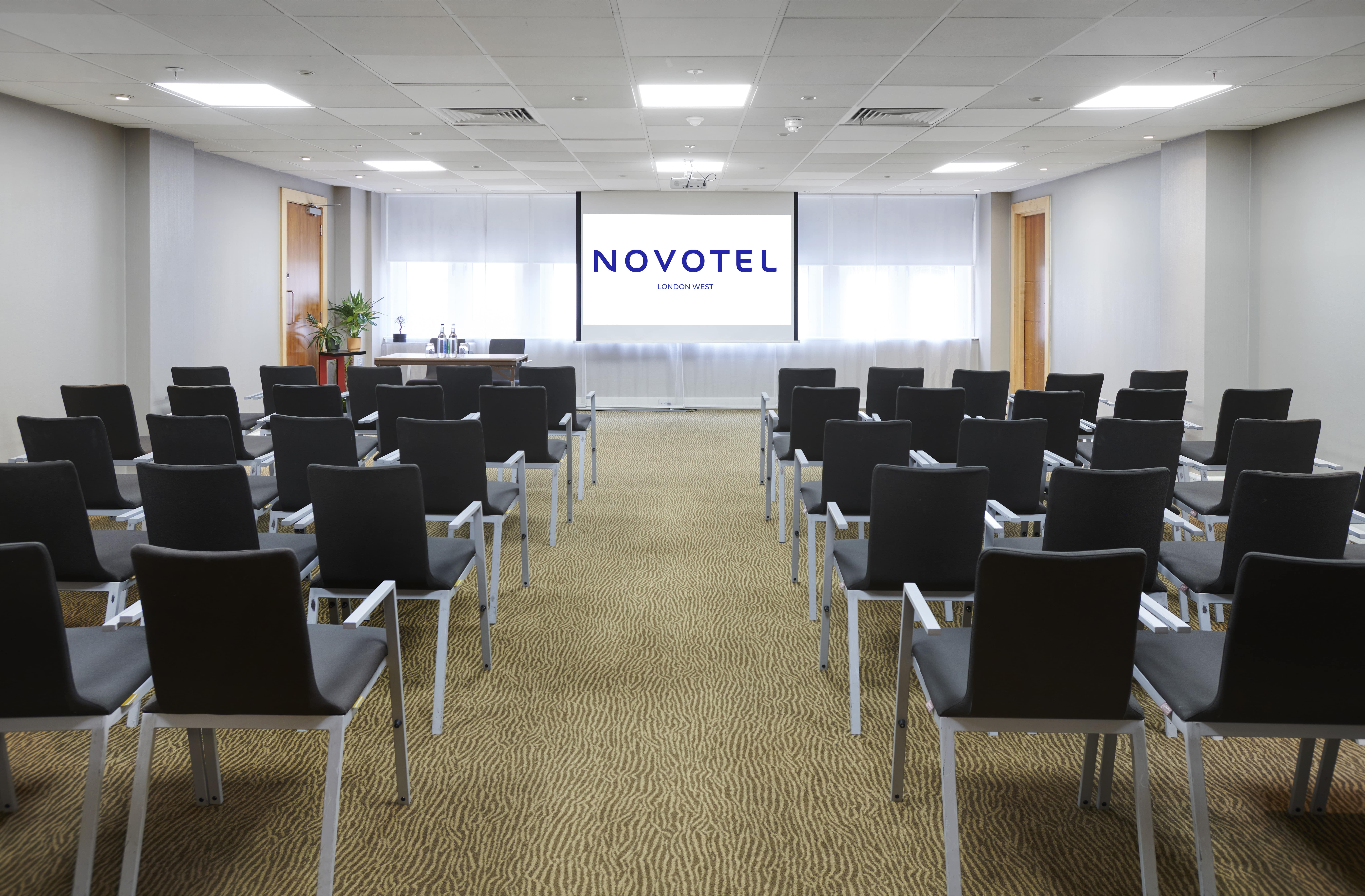 Meeting room at Novotel London West with black chairs, ideal for corporate events.