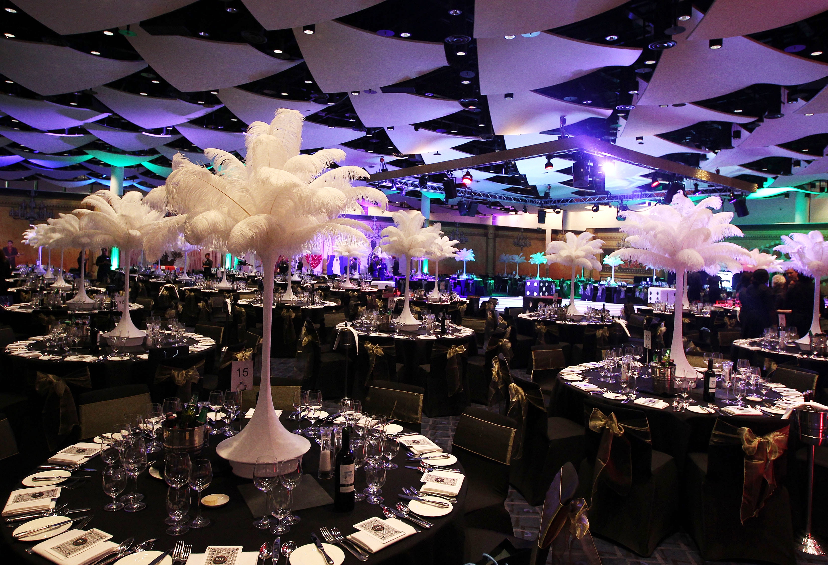 Elegant Great Hall at Wembley Stadium with feather centerpieces for corporate gala events.