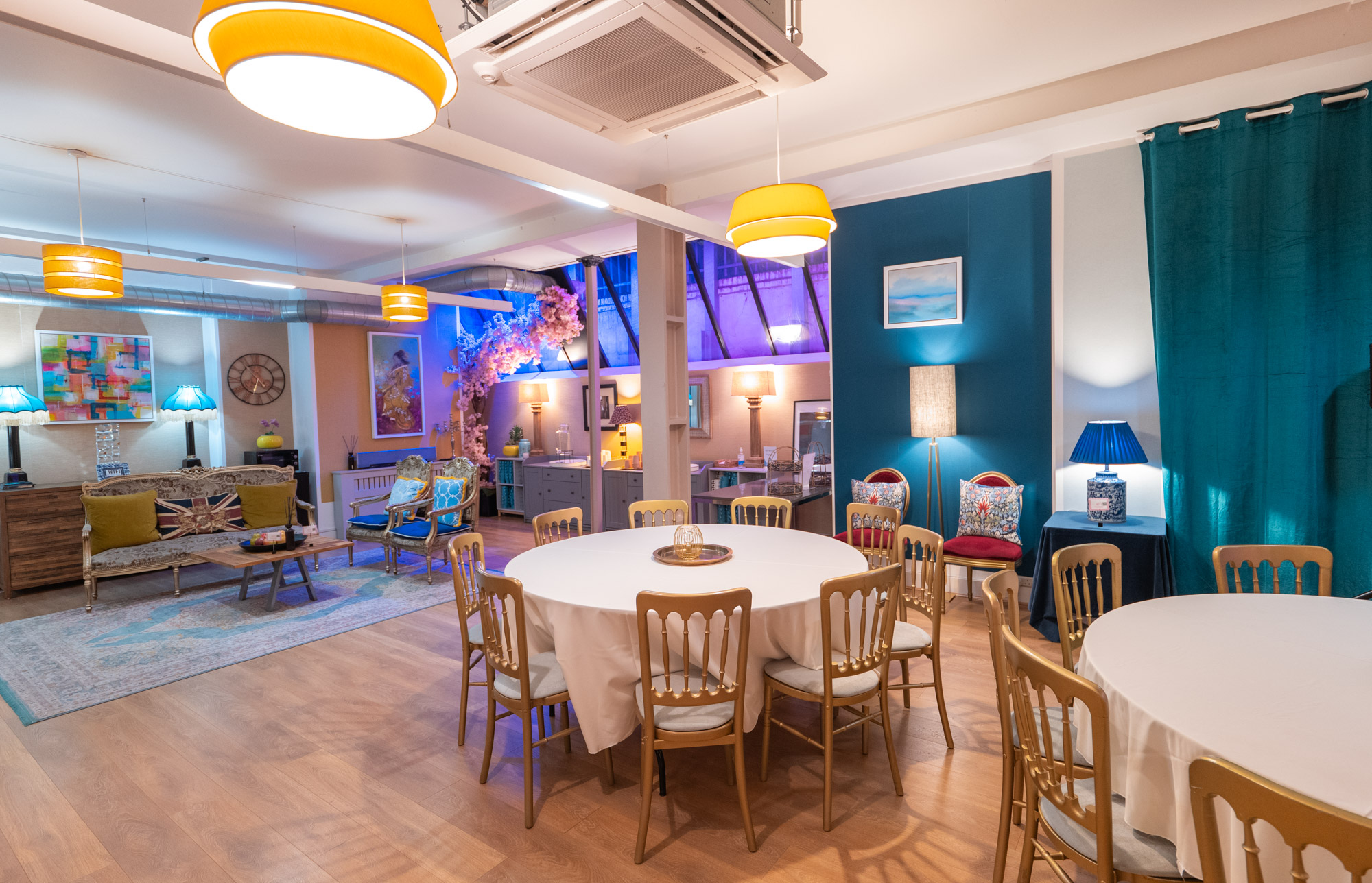 Versatile event space with round tables, warm lighting for workshops and small conferences. - Banner