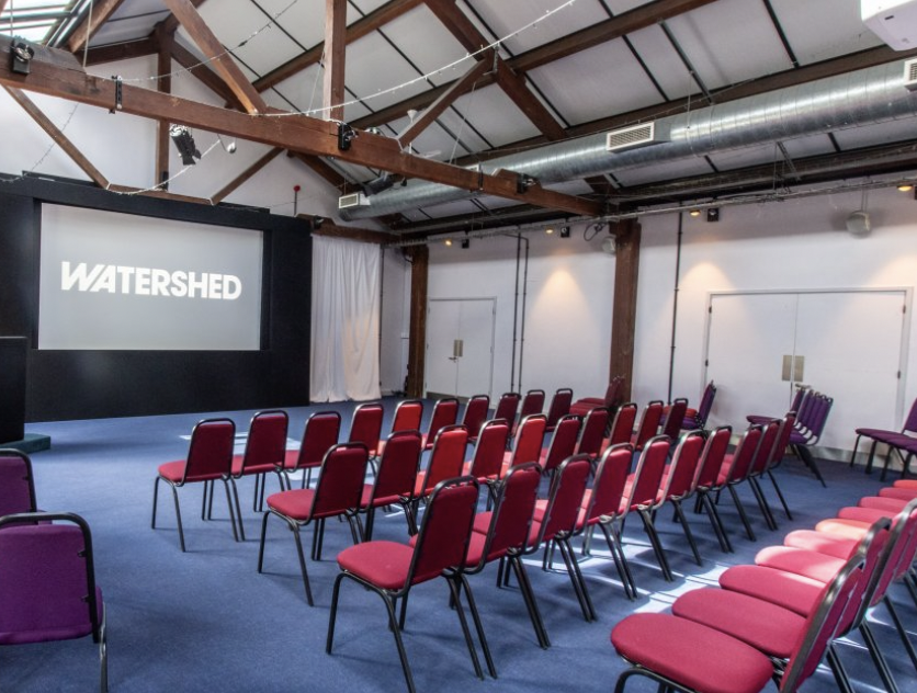 Versatile event space with stage and screen, perfect for conferences and workshops. - Banner