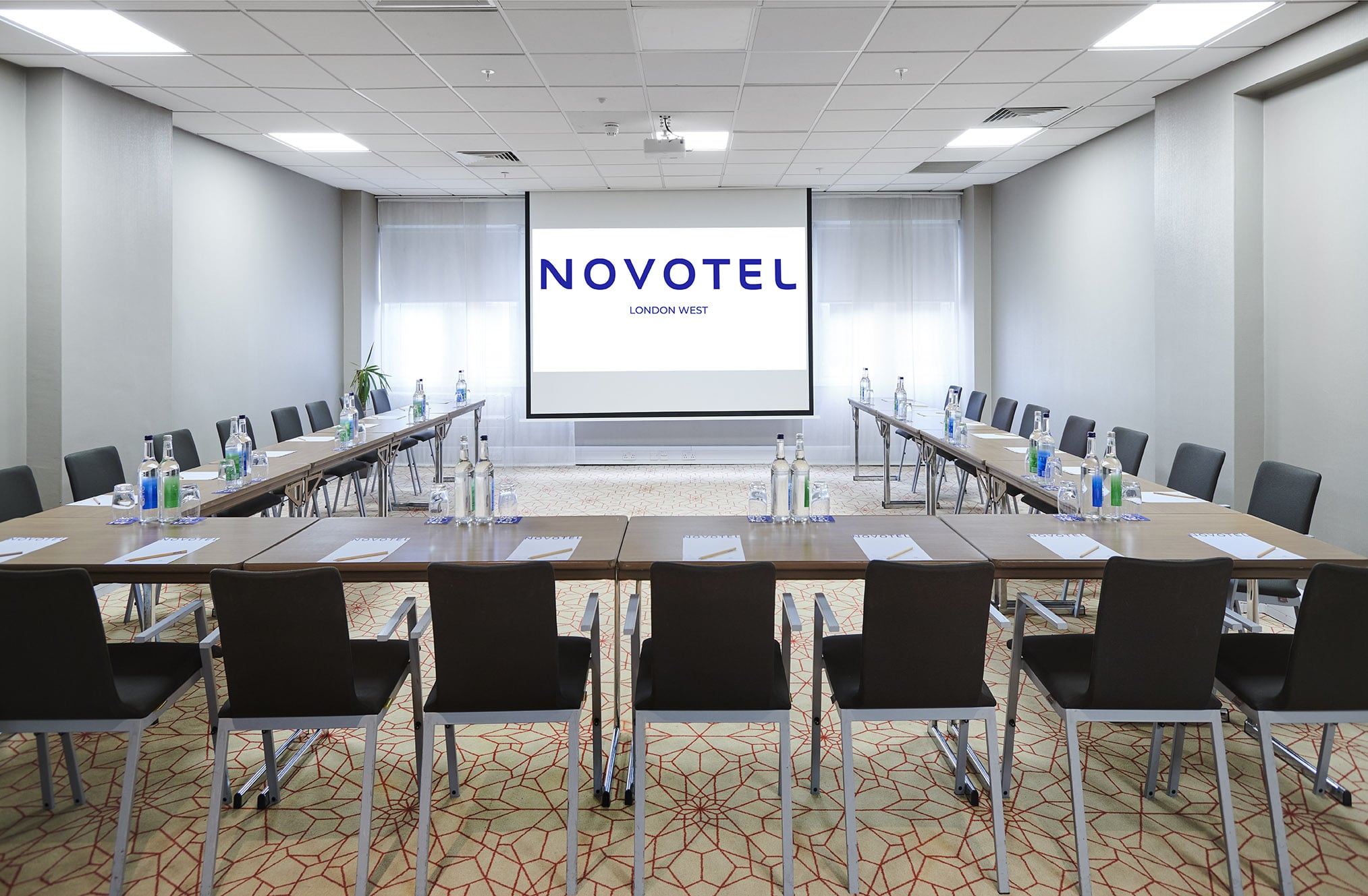 Modern meeting room in Novotel London West with U-shaped seating for corporate events.