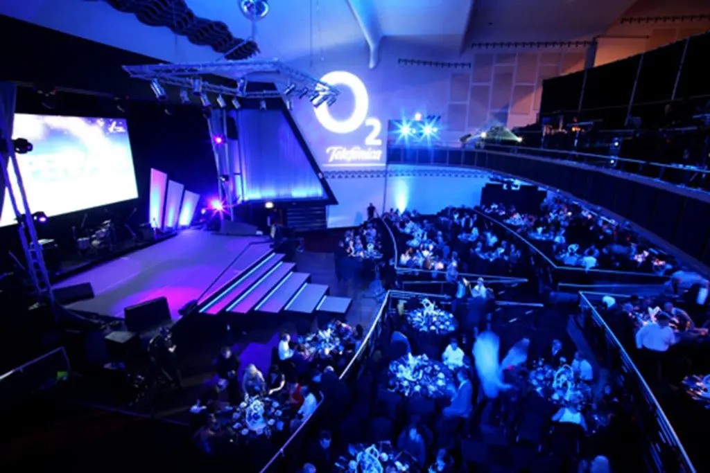 Vibrant Athena Space event setup with stage lighting for presentations and awards.