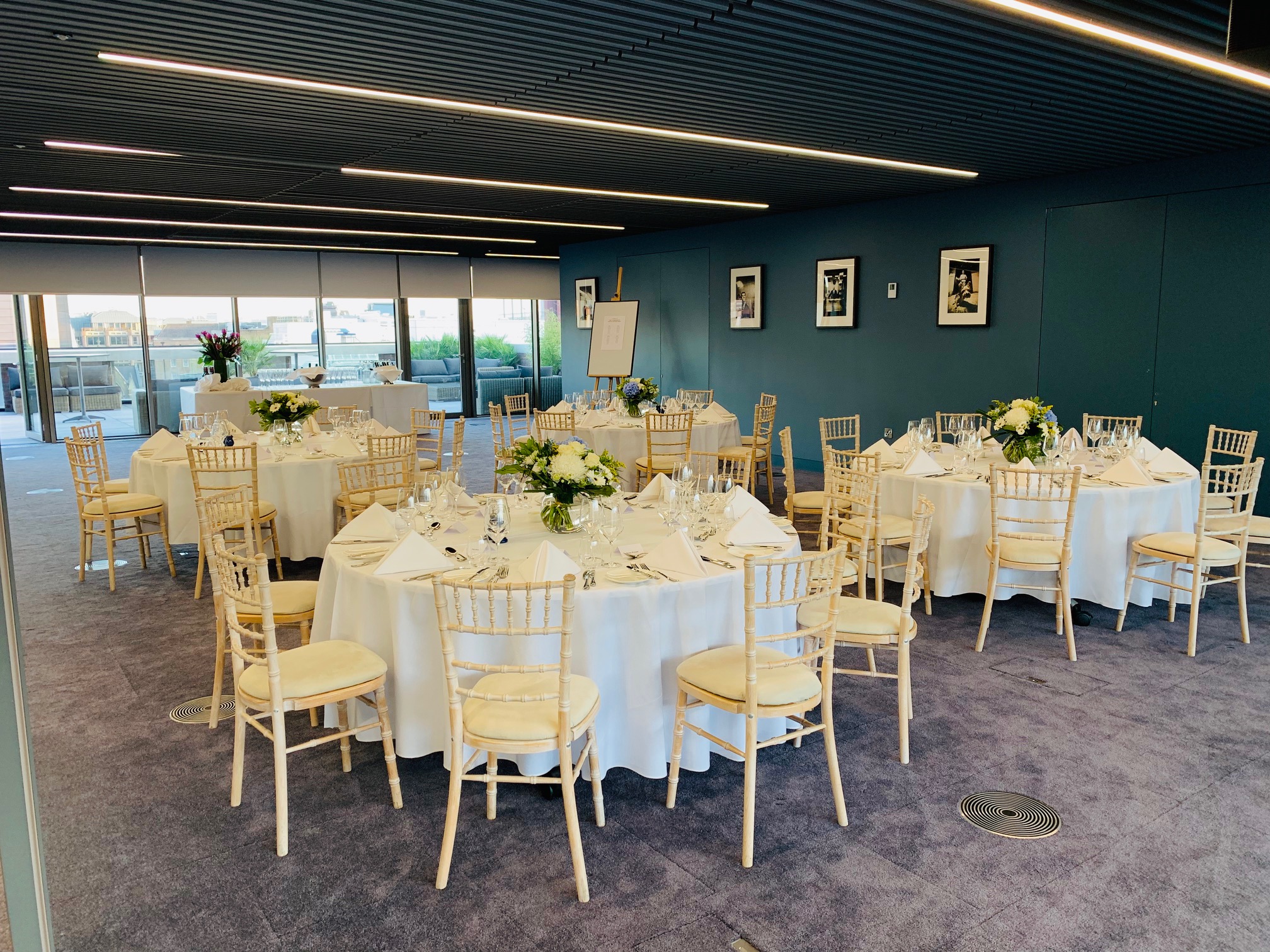 Summer Party Rooftop with elegant tables and floral centerpieces for corporate events.