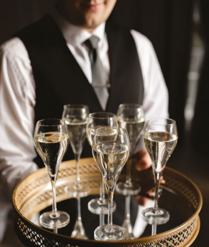 Christmas party waiter serving sparkling cocktails at Brookfield Barn.