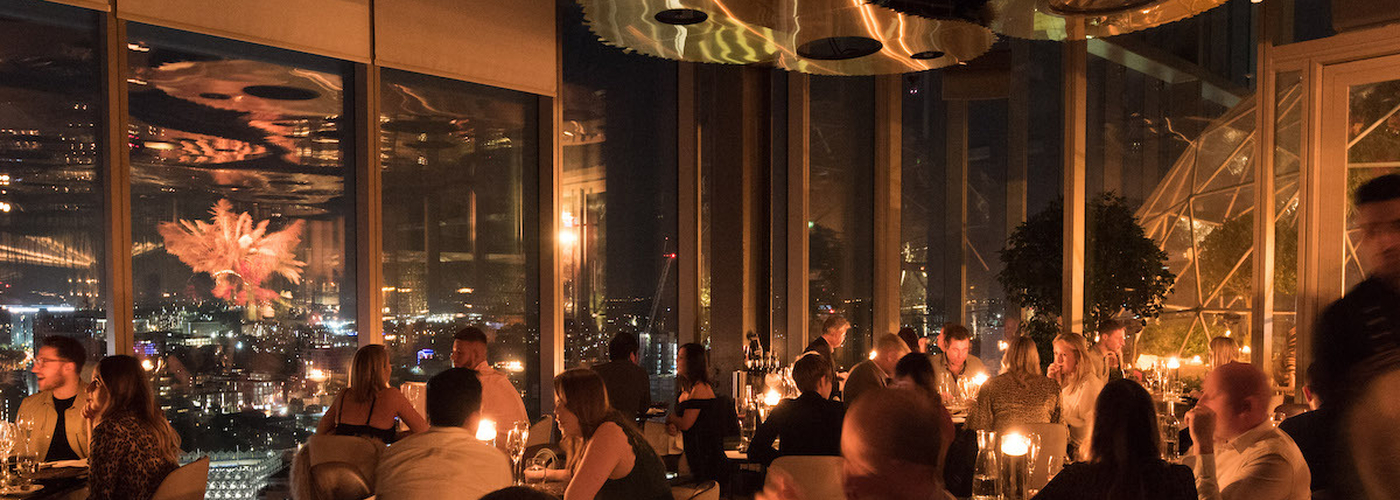 Intimate networking dinner table setup with floor-to-ceiling city views for corporate events.