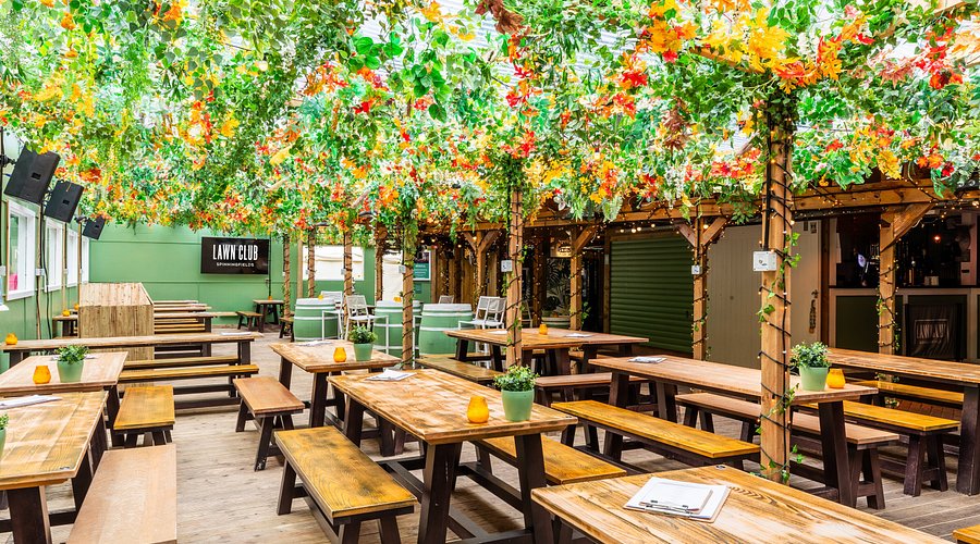 Vibrant cocktail bar with lush greenery, ideal for outdoor events and gatherings. - Banner