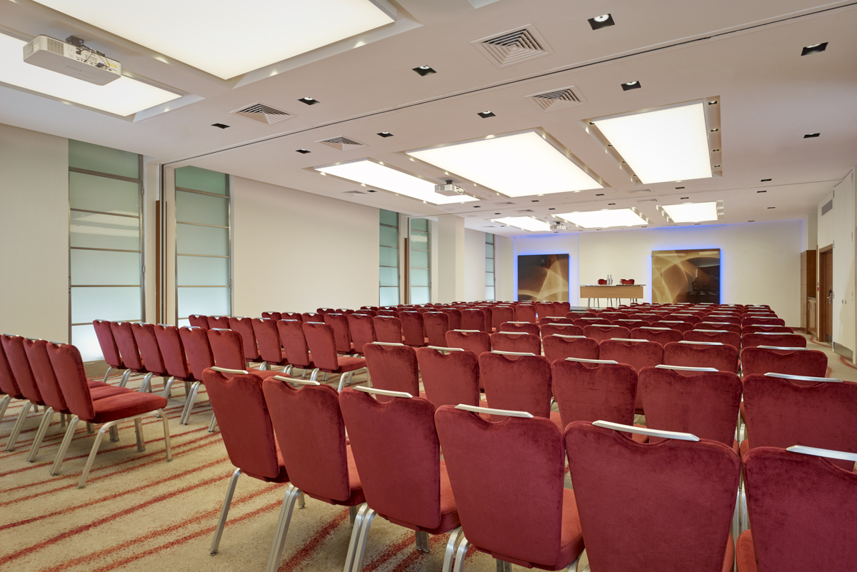 Spacious conference room with red chairs at Park Plaza Victoria, ideal for events and workshops. - Banner