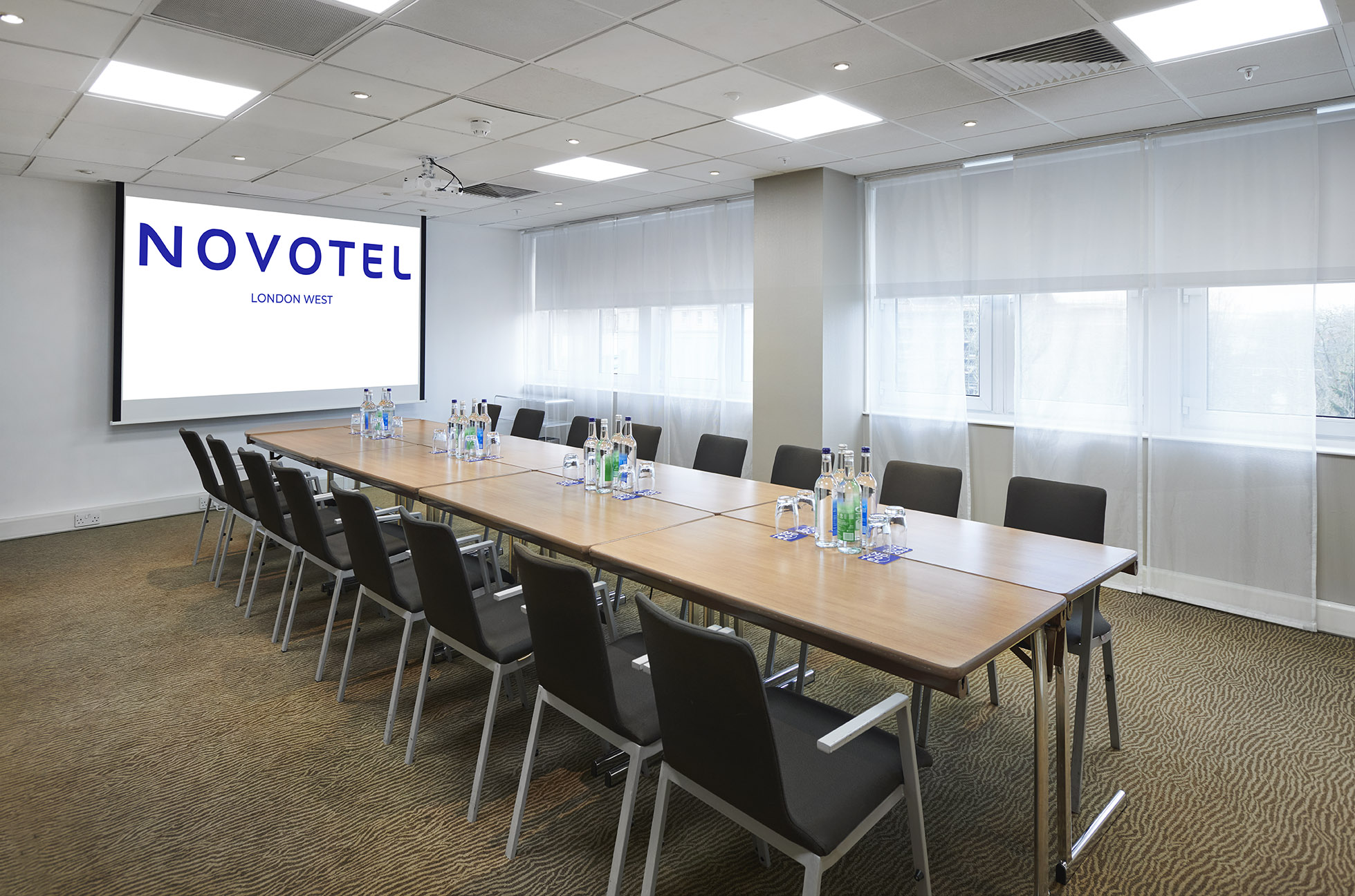 Modern meeting room at Novotel London West with large boardroom table for events.
