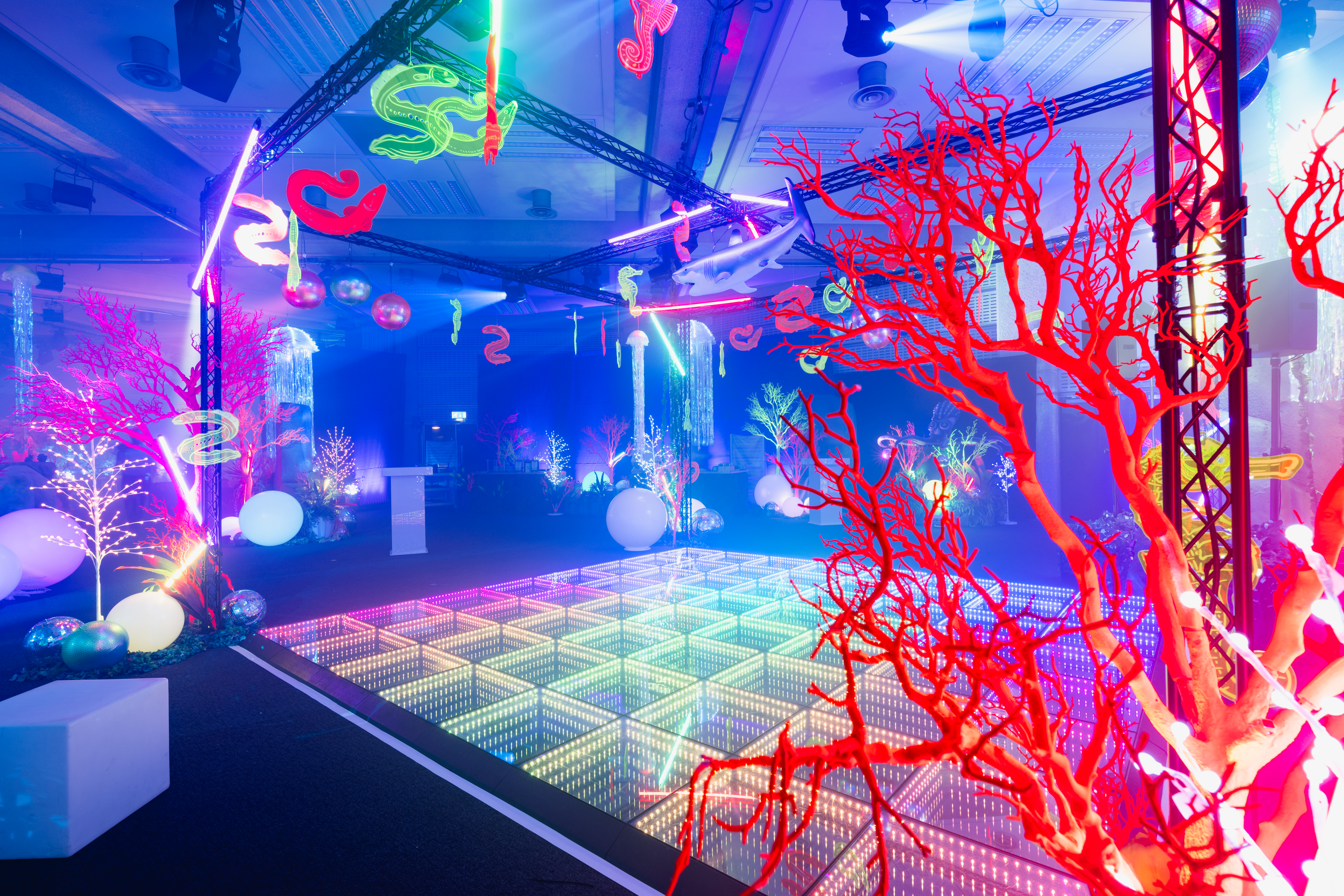 Vibrant event space with illuminated dance floor at QEII Centre, ideal for celebrations.