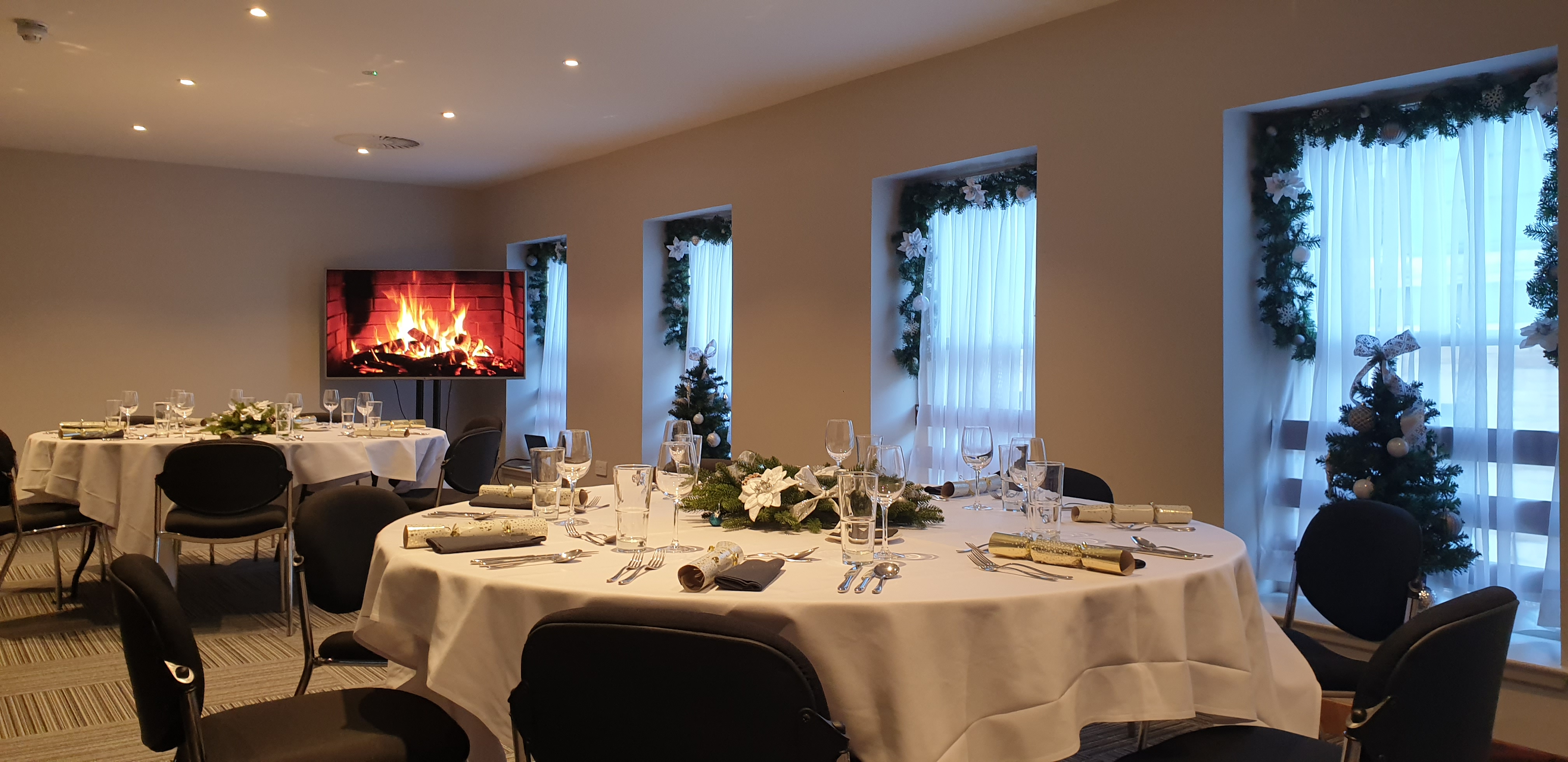 Elegant meeting space at The Baird, featuring round tables and soft lighting for events.