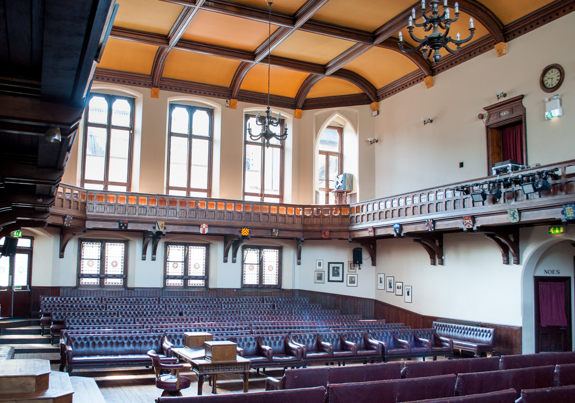 Cambridge Union Debating Chamber with tiered seating, ideal for conferences and discussions. - Banner