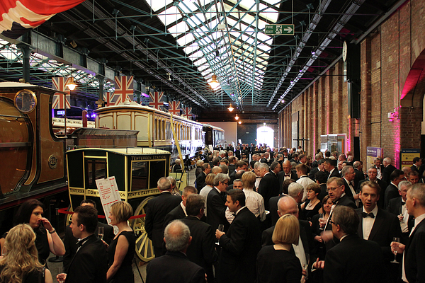 Elegant event in Station Hall, National Railway Museum with vintage vehicles backdrop.