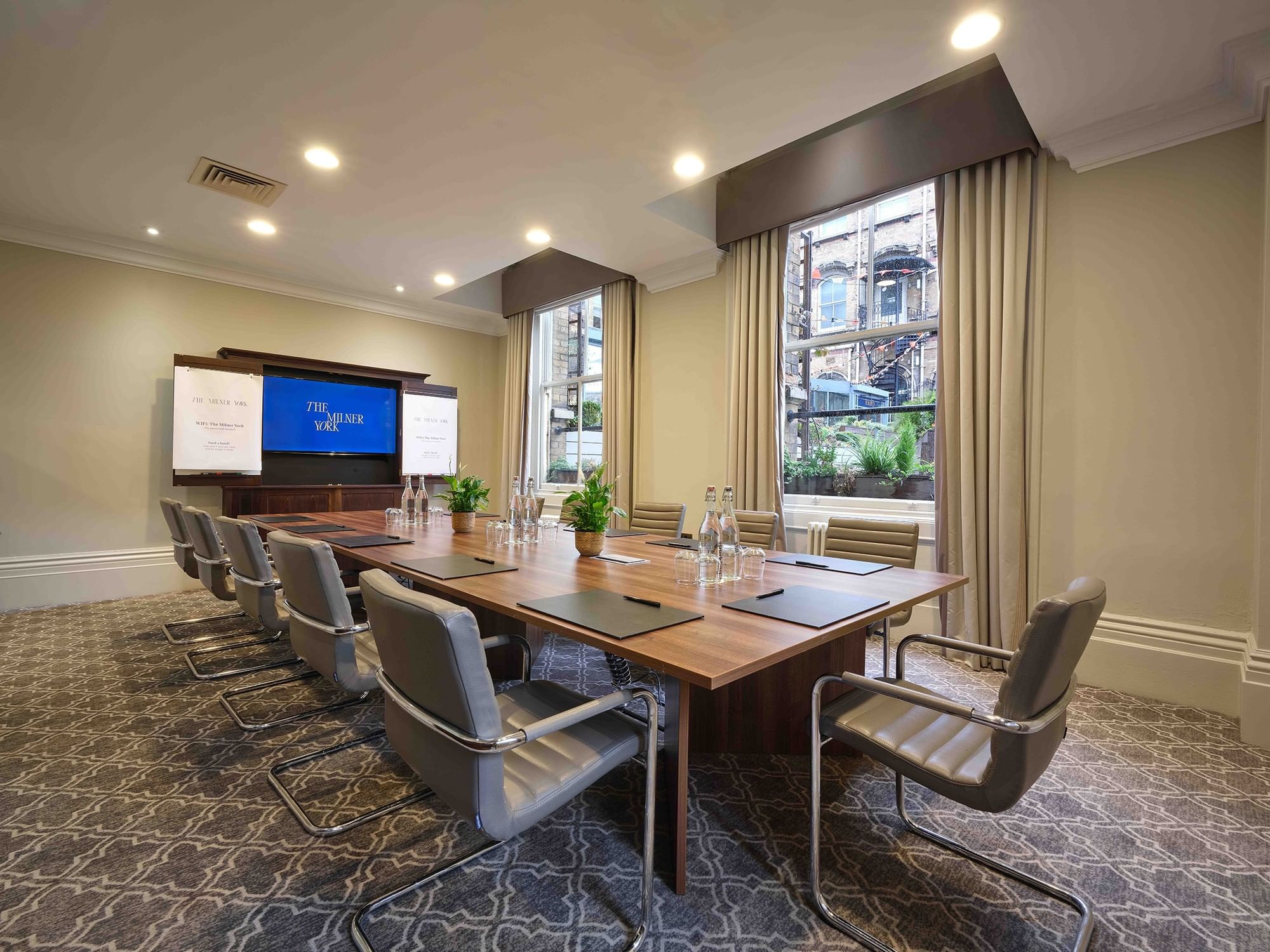Modern meeting room at The Milner York with large wooden table for corporate workshops.