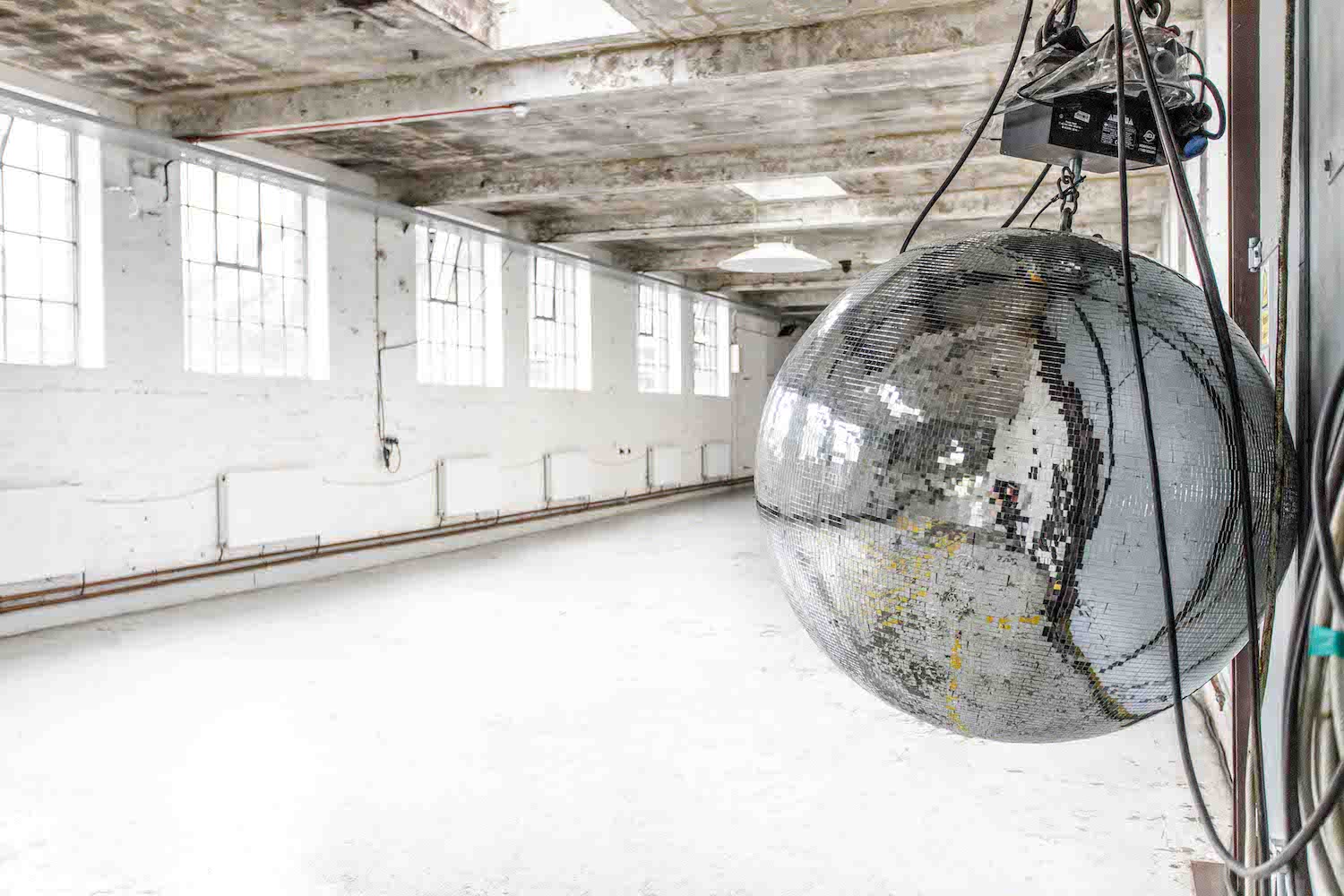 Penthouse event space in Electrowerkz with a large disco ball, ideal for gatherings.