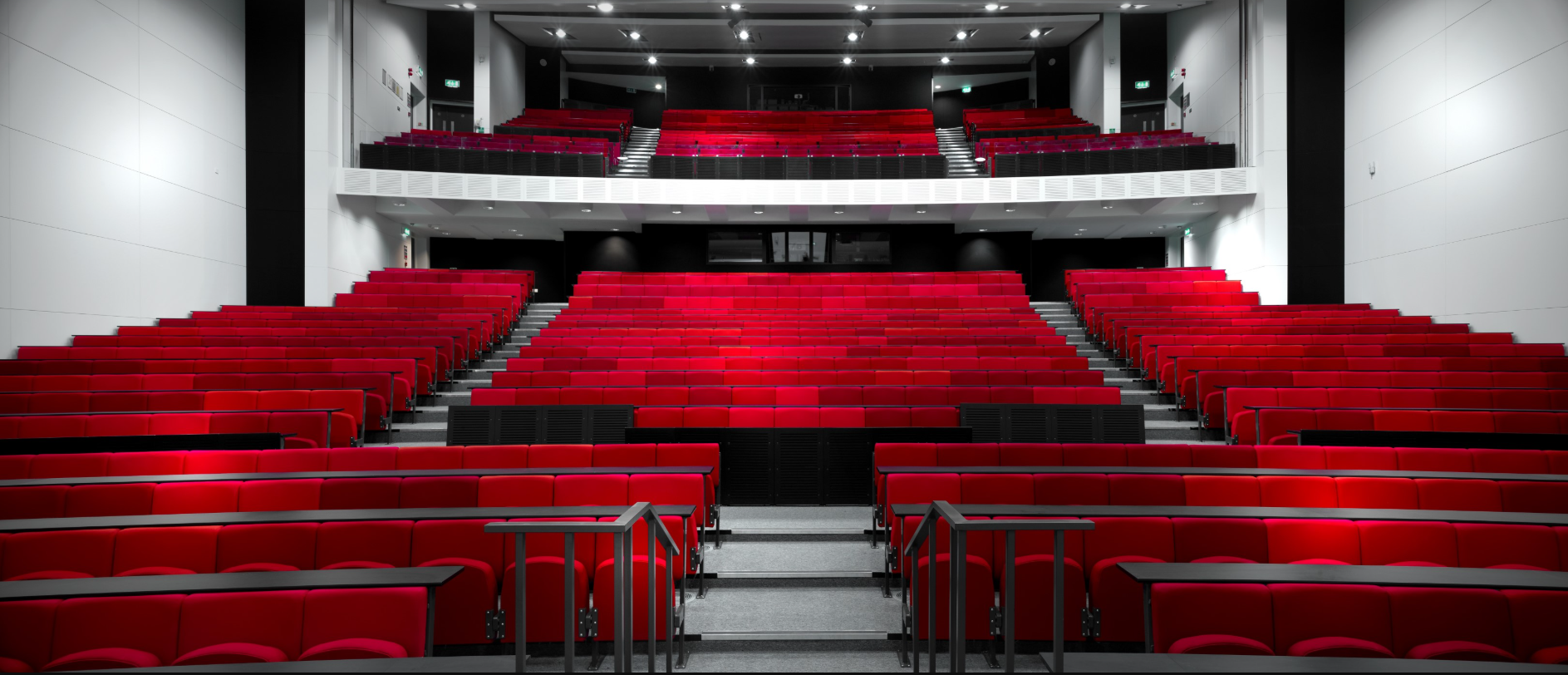 Modern auditorium at The University of Manchester with vibrant red seating for events. - Banner