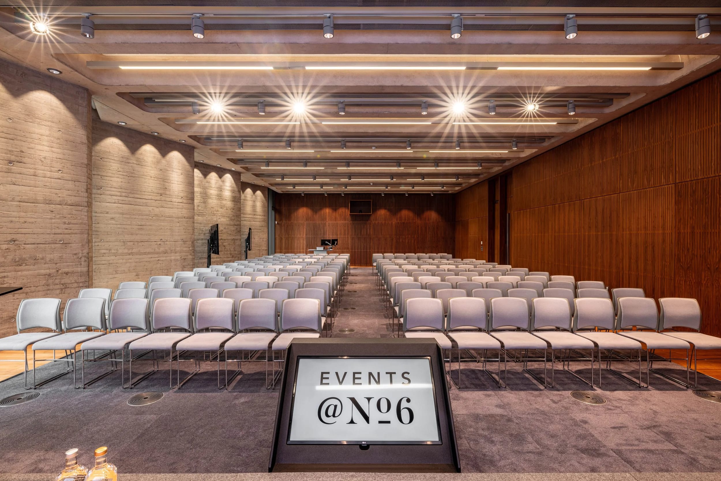 Modern theater-style conference room with wood paneling for keynote speeches and panel discussions.