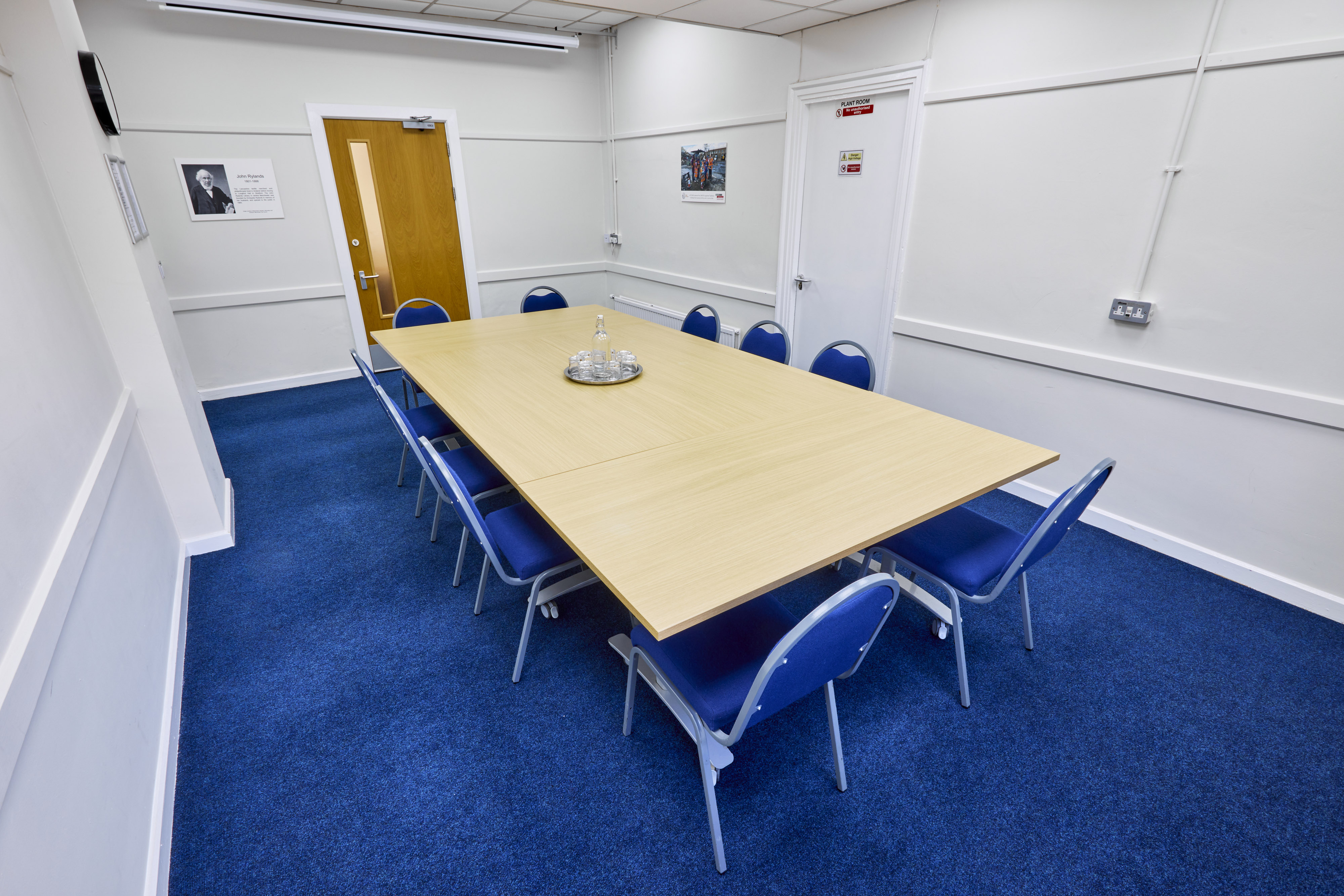 Rylands Room at St Thomas Centre: bright meeting space with wooden table and blue chairs.